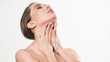 © wedmoments.stock - Portrait of an attractive dreamy tender girl doing a face and neck massage, isolated on a light background. Self care concept. Advertising of cosmetology and cleanliness.