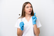 © luismolinero - Dentist woman holding tools isolated on white background thinking an idea pointing the finger up