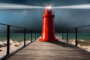 Old red lighthouse with light beams on a wooden pier with rough sea, storm clouds (cumulonimbus) and torrential rain on background. Photography.