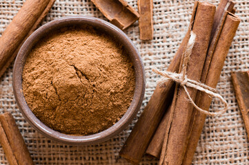 Wall Mural - Cinnamon sticks and cinnamon powder on dark rustic background, healthy spice, (Cinnamomum)