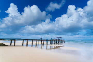 Wall Mural - Wooden pier bridge Extending into the Sea, Embracing Thailand's Eastern Island's Rocky Shores as day time.