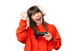 © luismolinero - Little caucasian girl playing with a video game controller over isolated background celebrating a victory