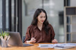 © David - Young attractive business asian woman checking searching document  her project with laptop computer in the office room.