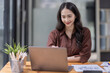 © David - Young attractive business asian woman checking searching document  her project with laptop computer in the office room.