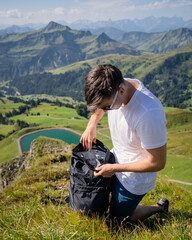 Wall Mural - Hiker backpacker enjoying lake view alone outdoor Travel adventure in active vacations healthy lifestyle eco tourism man 