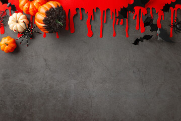 Wall Mural - Halloween scene installation. High-angle top view featuring themed decoration layout: pumpkins, creepy spiders, spiderweb, bats, blood smears on textured concrete wall. Open area for text placement