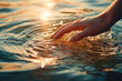 © MVProductions - Closeup of a woman's hand touching the lake water, causing ripples. A concepts of cleansing, nature, environment and sustainability