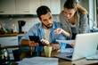 © Geber86 - Worried young Caucasian couple going over their bills and home finances in the morning in the kitchen