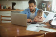 © Geber86 - Young single father going over his bills and home finances while his daughter uses the tablet in the morning in the kitchen