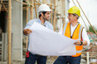 © offsuperphoto - workers or architect holding plan blueprint paper at construction site