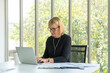 © janonkas - senior business woman using computers laptop while looking document at the office.