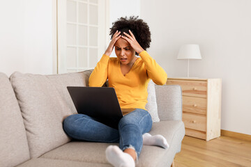 Wall Mural - Frustrated Black Woman Working At Laptop Clutching Head At Home