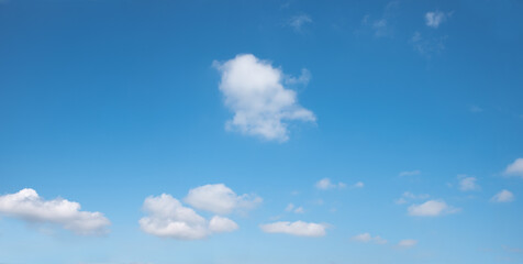 Wall Mural - soft sky panorama with floating clouds, one tiny cloud in the middle