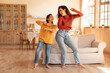 © Prostock-studio - Arab Mom And Daughter Dancing Together Standing In Modern Home