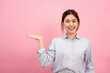 © Katcha - Young asian woman wearing long sleeve shirt and smiling while open one hands to presenting and advertising