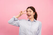 © Katcha - Young asian woman wearing long sleeve shirt while using hand and fingers to showing v sign gesture and winkle