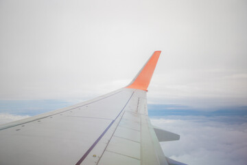 flying above white clouds. Right wing of the airplane above the white clouds