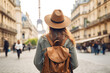 © pilipphoto - Back view of happy woman with hat and backpack enjoying vacation in Paris