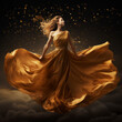 Beautiful fashion model in golden silk gown flowing fabric