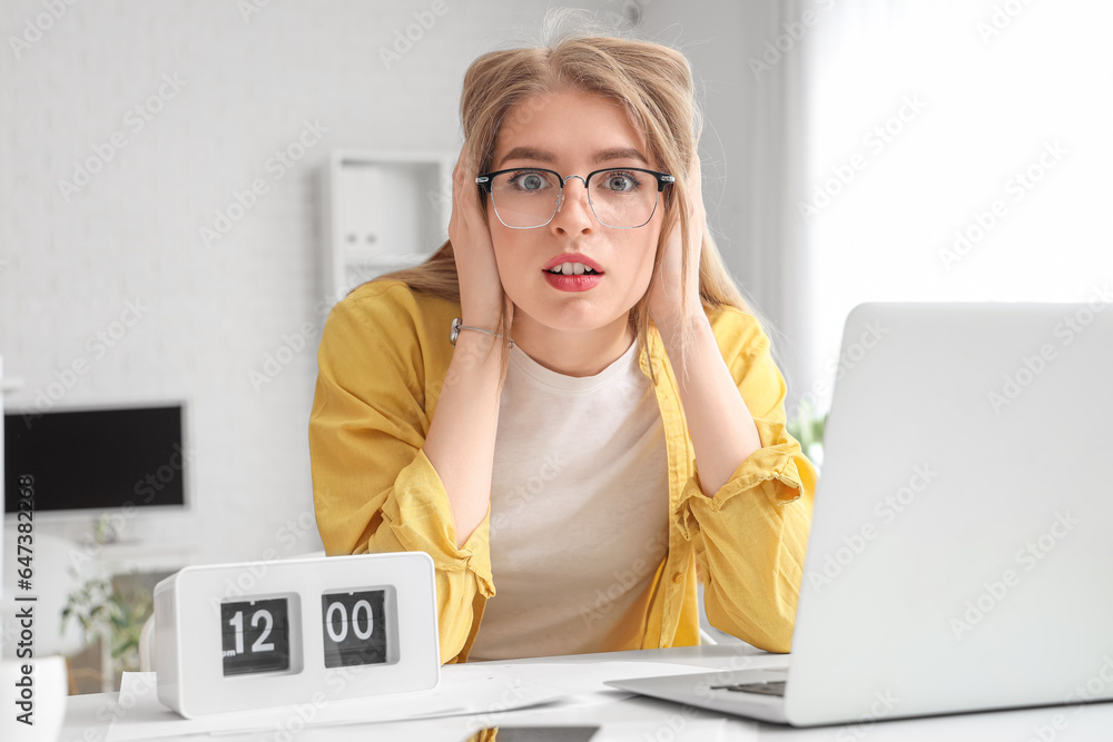 Stressed young businesswoman working under deadline in office
