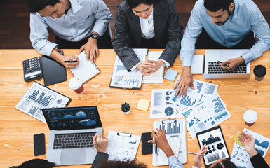 Wall Mural - Top view multiracial analyst team use BI dashboard data to analyze financial report on meeting table. Group of diverse business people utilize data analysis by FIntech for business decision. Concord