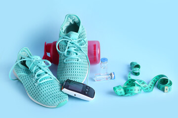 Wall Mural - Glucometer with sneakers, tape measure and insulin on blue background. Diabetes concept