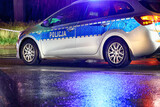 Fototapeta  - Policja polska radiowóz w akcji na ulicy w ruchu. Policja w deszczu. 