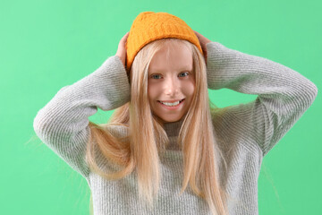 Poster - Little girl in hat on green background, closeup