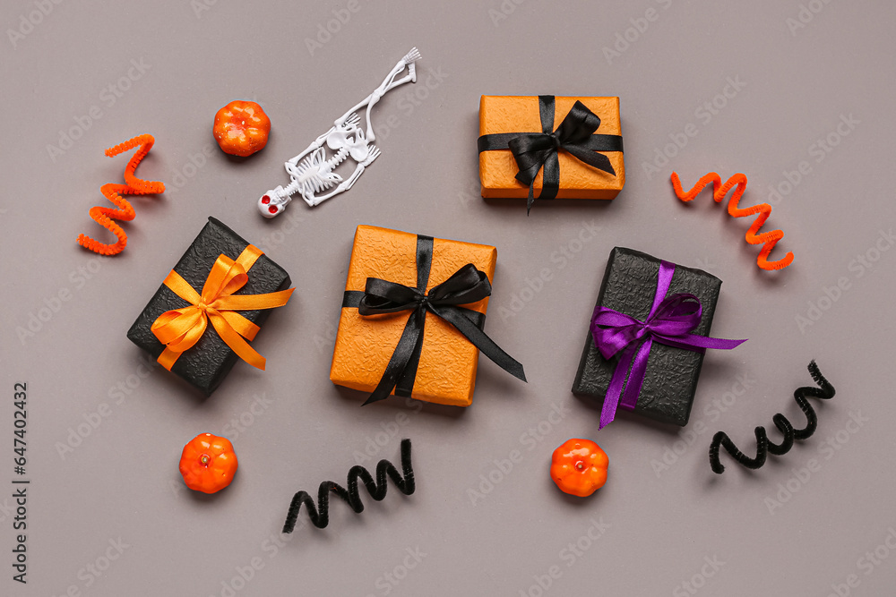 Composition with different gift boxes and Halloween decorations on grey background