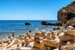 Unzählige zu Steintürmen gestapelte Steine in einer Bucht an der Algarve