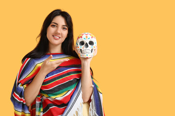 Canvas Print - Beautiful young woman with painted skull on yellow background. Mexico's Day of the Dead