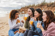 © PintoArt - Group of young multiracial people celebrating and drinking alcohol on a tropical beach.