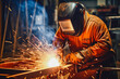© VisualProduction - Welder man at work in his workshop while wearing a safety protection gear, focus on work