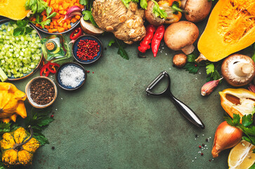 Wall Mural - Autumn food. Pumpkin, mushrooms, roots and vegetable peeler. Ingredients for vegan, vegetarian cooking. Fall harvest. Healthy diet eating, slow food concept. Rustic green table background, top view