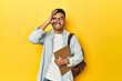 © Asier - Asian student with backpack and notebook, yellow studio backdrop excited keeping ok gesture on eye.