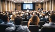 © ibreakstock - Rear view of unrecognized participants in audience at business meeting, speaker giving a talk on stage