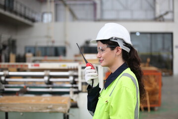 Wall Mural - worker or engineer working in factory with safety uniform , safety hat and safety glasses , image is safety concept or happy workplace