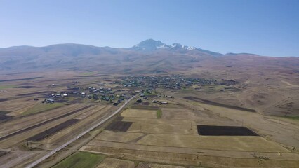 Wall Mural - Forward reveal aerial shot of Geghadzor village and Mount Aragats on sunny summer day. Aragatsotn Province, Armenia.