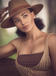 The photo depicts a captivating close-up portrait of the female model with curly hair and grey eyes, elegantly posed in a beige crochet beach dress and straw hat, against a natural blurred backdrop 