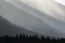 Light Shines Through The Rain As It Falls On The Mountains Along The Wind River In The Peel Watershed; Yukon, Canada