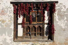 Dried Red Peppers Hanging In A Window; Paro, Bhutan