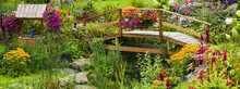 Flowers In A Garden With A Wooden Bridge Over A Stream; Granby, Quebec, Canada