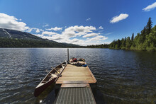 Three Adults And Young Girl Lounging On A Boat Dock On A Lake Soaking Up The Sun, Byers Lake Campground, Denali State Park; Alaska, United States Of America