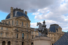 Statue And Buildings At The Louvre Museum In Paris; Paris, France