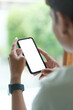 © wattana - View over shoulder of man hands holding smart phone. Empty screen for your advertise text.