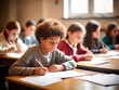 © sinseeho - School kids writing on notepad in the classroom. Taking examination or doing homework concept.