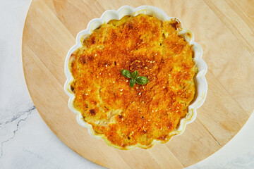 Sticker - Potato and pumpkin gratin in white bowl on wooden stand