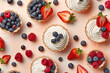 Top view of small tarts with cream and berry fruits surrounded by ingredients