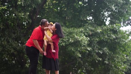 Wall Mural - Asian family happy. Father, mother kiss daughter footage shot in 4K UHD 3840x2160