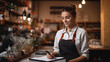 © JKLoma - female waiter stands on the background of the restaurant writes down the order in a notebook